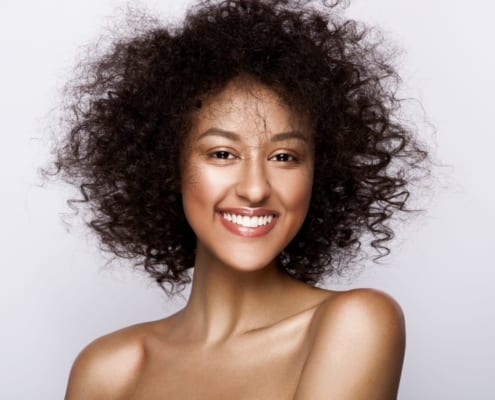 Fashion studio portrait of beautiful african american woman with perfect smooth glowing mulatto skin, nude make up